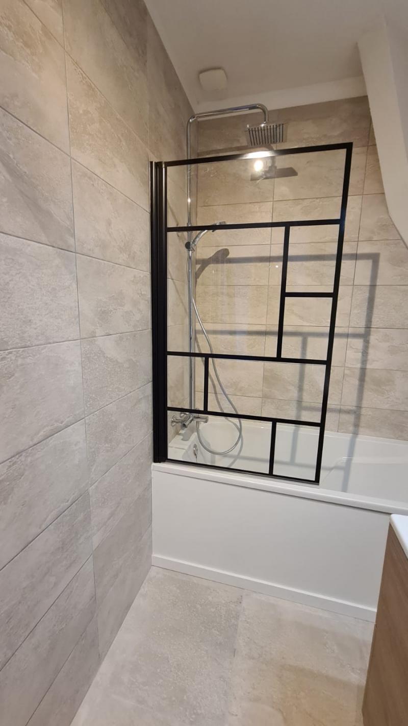 Rénovation complète d'une salle de bain avec paroi de douche au style industriel 
