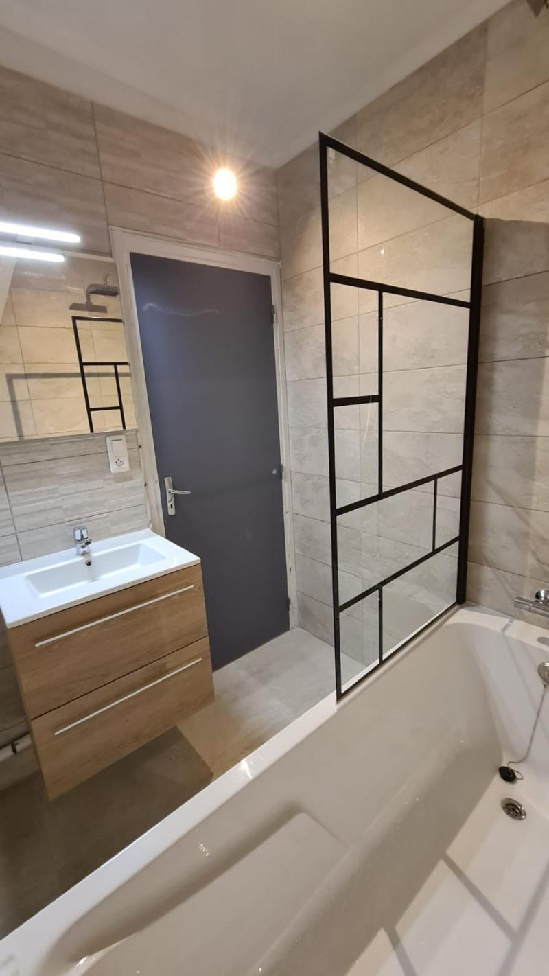 Rénovation complète d'une salle de bain avec paroi de douche au style industriel 